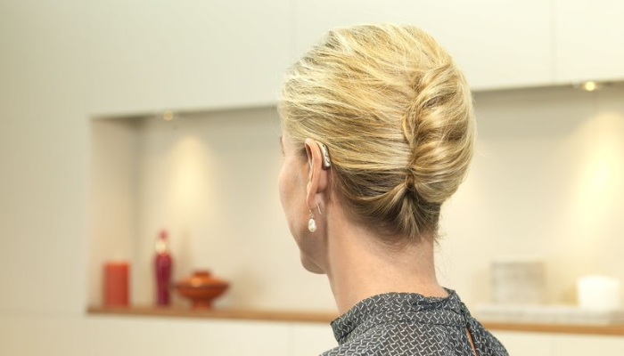 Bernafon: Woman from behind with a hearing device on the ear