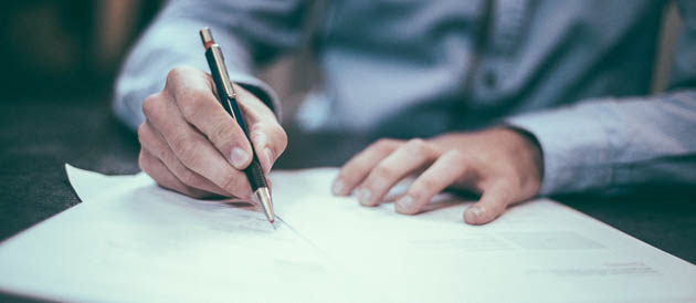 A man with a pen writing a report